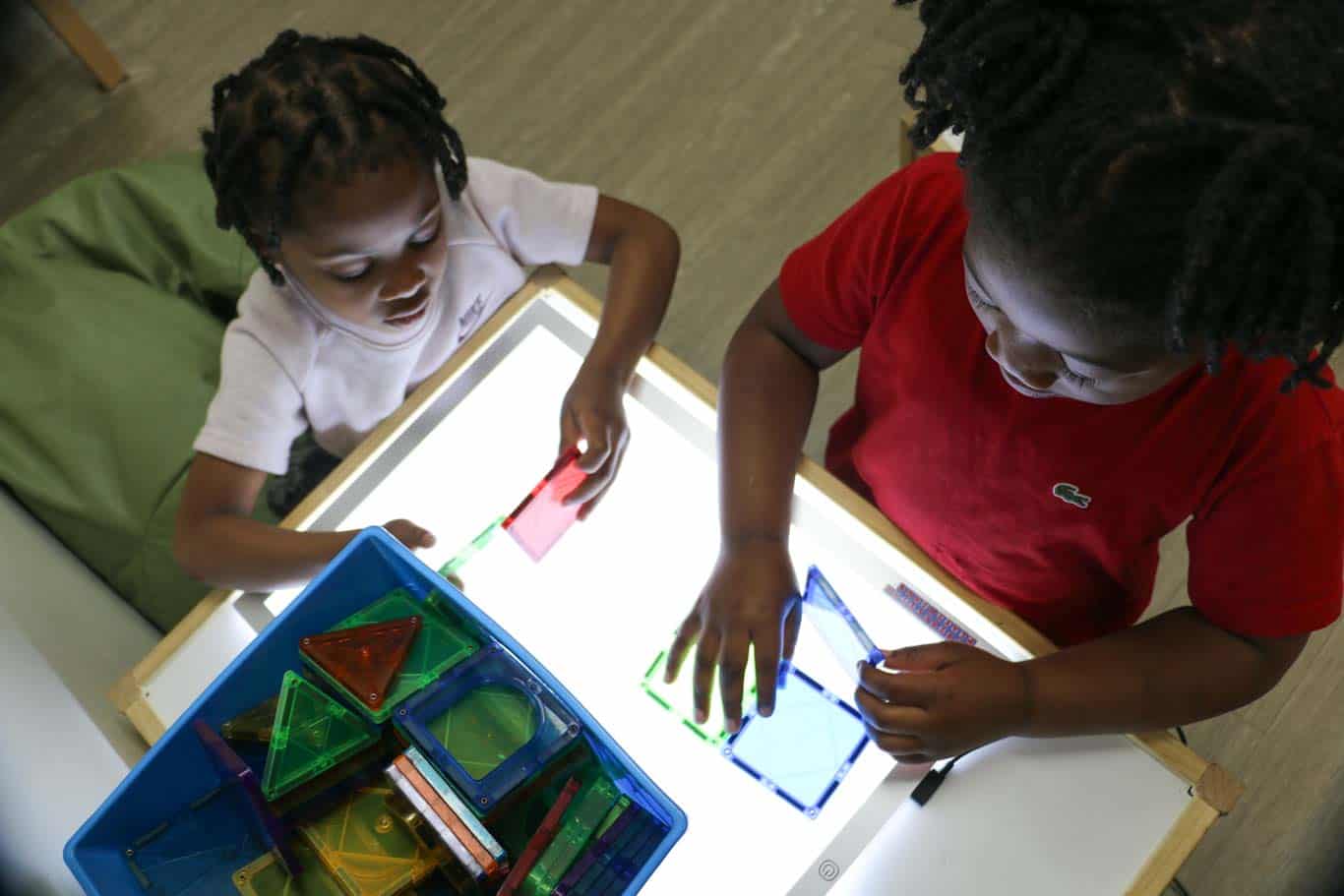 Children playing at a light table